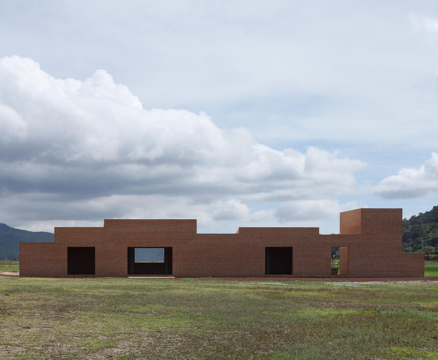 A brick house elevation against an open landscape.